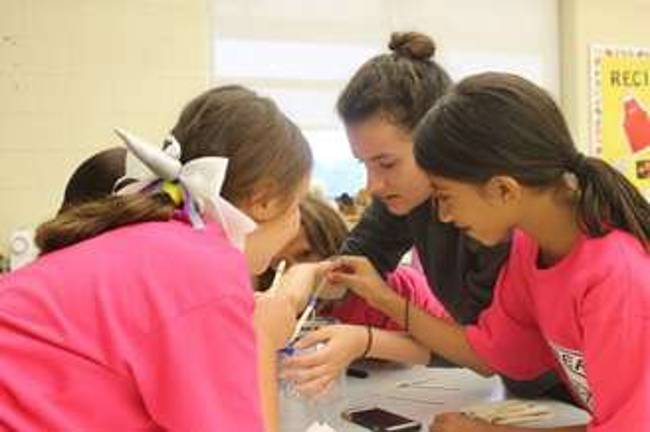 Bella Covell, Sussex County Technical School senior, engages campers in a popsicle bridge experiment.