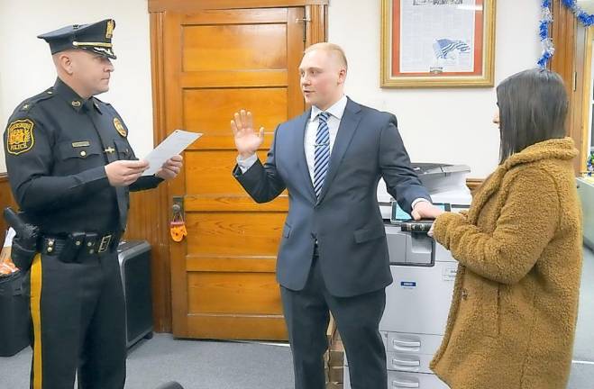 Newly appointed Police Officer Richard J. Luthcke takes the Oath of Office with Police Chief Stephen Gordon on left and Alyssa Mullen on right.