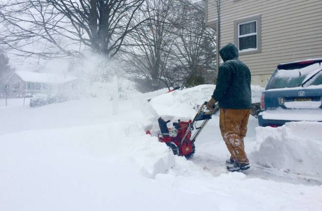 A man snowblows during Tuesday's storm.