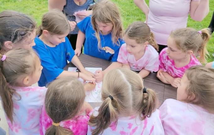 Girls in the Daisies troop play a puzzle game.