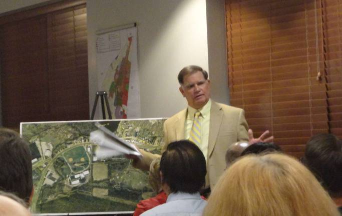 Kenneth Nelson, owner of Nelson Consulting Group and author of the 45-page report on the properties included in the area in need of redevelopment, explains his report to the crowd and planning board.