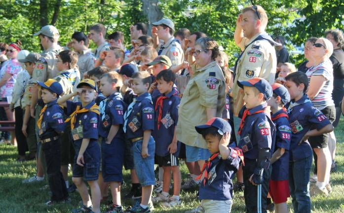 Scouts from Cub packs 90 and 298 and Boy scouts from Troop 90 salute during the retirement ceremony.