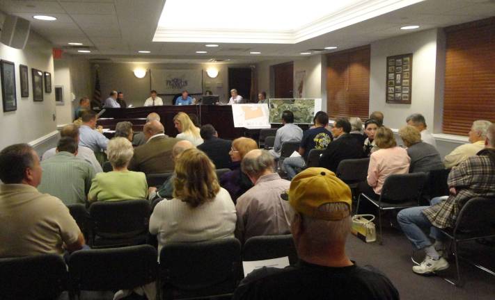 The crowd files in early as the planning board sits on the dais, preparing to discuss &quot;Area E.&quot; Photos by Scott Baker