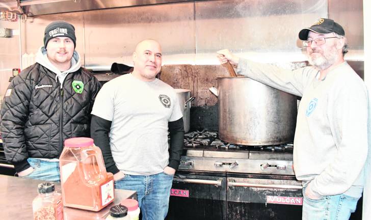 Firefighthers William Gunderman, William Colon and Bill Pierce, all of Ogdensburg, are shown cooking.