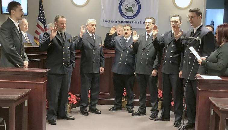 Municipal Clerk Darlene Tremont, right, administers the oath of office to Franklin Fire Department officers. At left is Fire Chief Khyle Conklin.