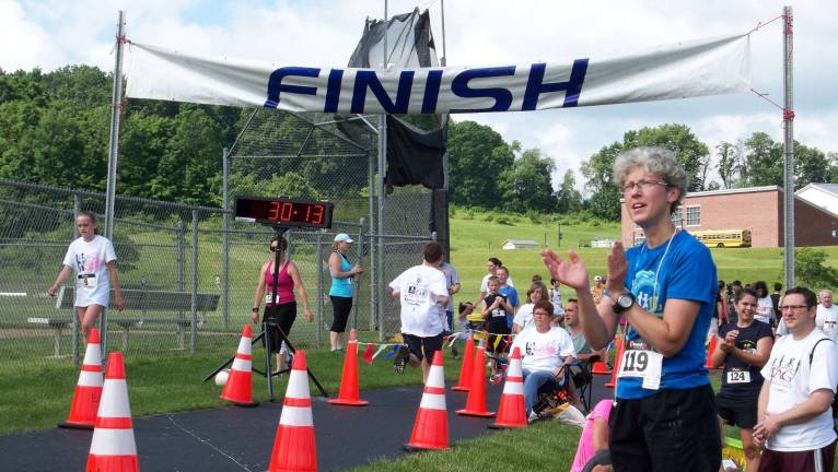 After finishing second in the womens division, Carol Cewino cheers on her fellow racer Zachary Wolverton.
