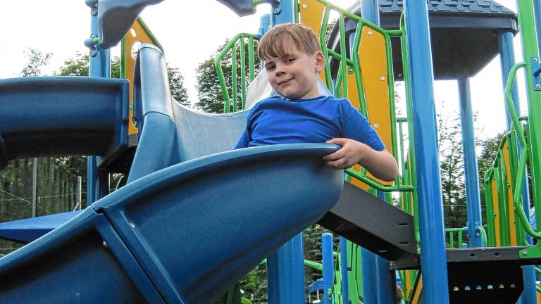 Aidan Heninger-Lowell, 7, goes down the slide at the new completely inclusive playground at C.O. Johnson Park in Byram. (Photo by Theresa Esposito)