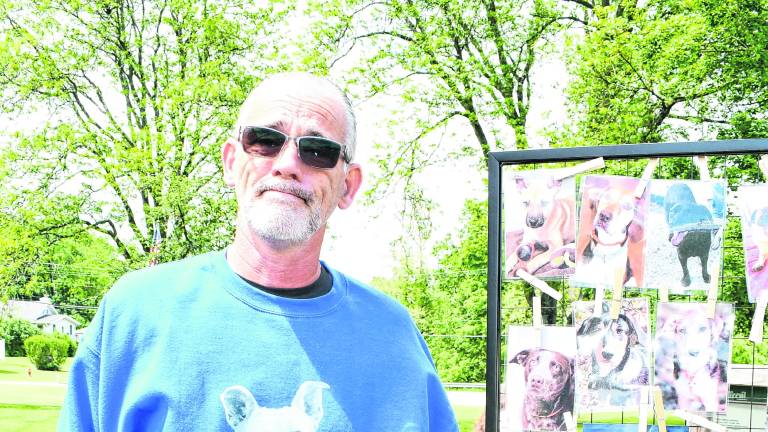 Jerry Nicholson points at a picture of his dog, Hendricks.