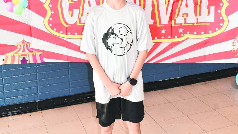 Giovanni Pagan poses in front of a sign.