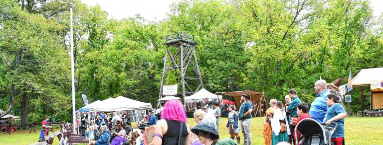 Festival attendees watch the sword-fighting.