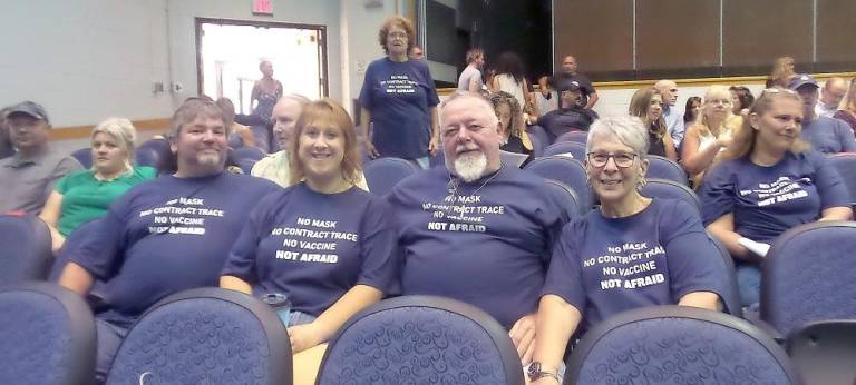 Many attendees wore tee shirts sold at the meeting opposing Covid safety measures (Photo by Frances Ruth Harris)