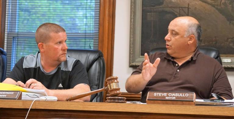 On right, Mayor Steve Ciasullo discusses security equipment quotes with Councilman Robert Gunderman, on left.