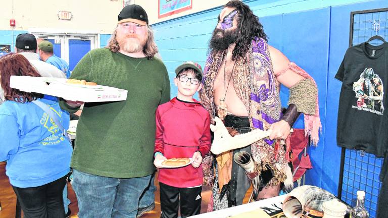 Rob Maloney ( holding pizza) and Reynaldo Sandoval, both of Vernon, pose with Yoscifer the Barbarian.
