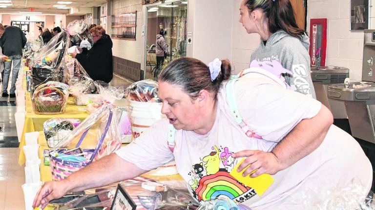 Hailey Babcock of Harydston places a ticket in a bag as Laurielei Gomolla of Newton looks at the table. About 250 tickets were sold.