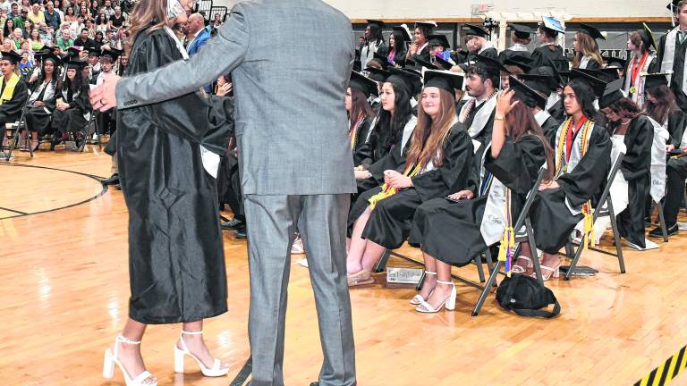A graduate receives her diploma.