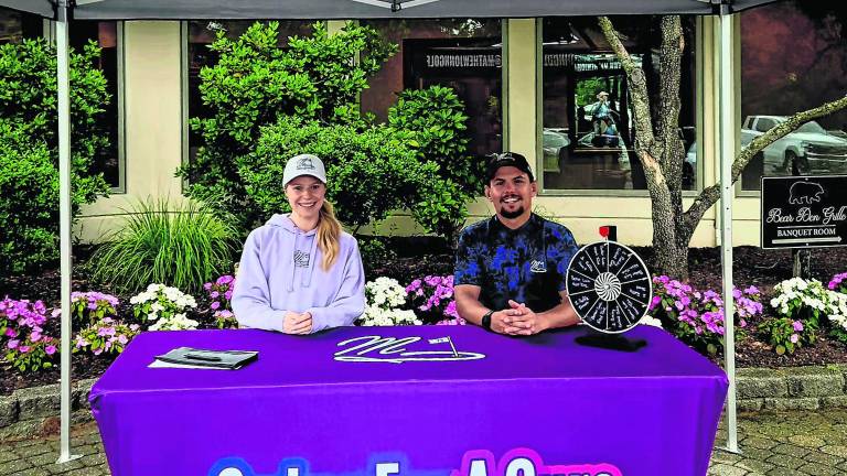 Rachel Mastrangelo and Matthew Magura, the fouder of Swing For a Cure, sit at a table.