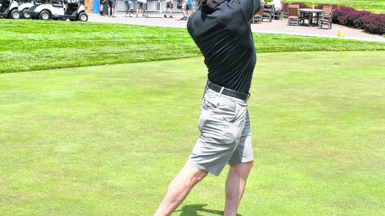 John Spoon of the Sparta Police Dept. drives his shot.